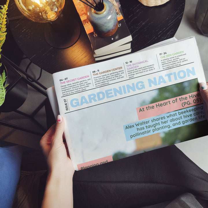 A person holding a copy of Gardening Nation magazine in a cozy indoor setting, with hands visible holding the pages open. The top of the magazine cover features the title 'GARDENING NATION' in large blue letters, with article previews below.